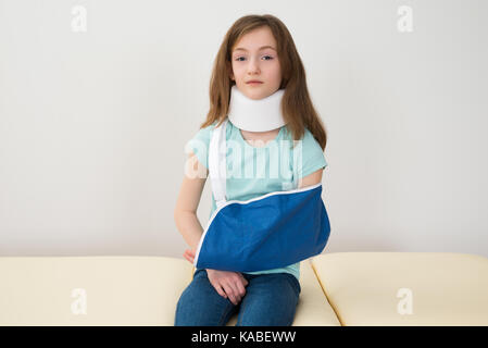 Portrait von Mädchen mit Neck Brace und Arm Schlinge Stockfoto