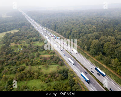 Luftaufnahme von einer Autobahn in Deutschland. Stau in eine Richtung. viele Lkw und kleine Autos im Stau stecken geblieben Stockfoto