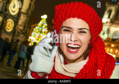 Magic auf Straßen der Altstadt zu Weihnachten. Portrait von lächelnden Jungen touristische Frau in Rot Hut und Schal zu Weihnachten in Prag Tschechische Republik spea Stockfoto