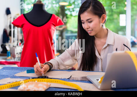 Asiatische Modedesigner der Ausarbeitung von Entwürfen für Aussparungen Stockfoto