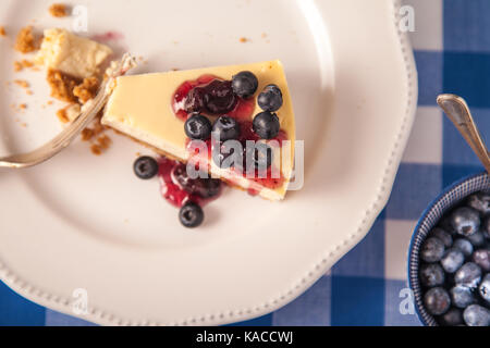 Käsekuchen auf einem Teller mit Blaubeeren Stockfoto