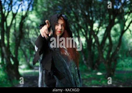 Hexe punkte Finger vorwärts im dunklen Wald Stockfoto