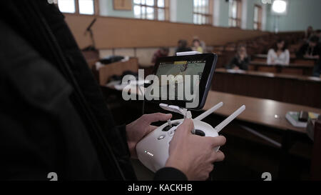 Nahaufnahmen der Hände des Menschen mit einer Fernbedienung Fliegen eine kleine quadcopter Spielzeug drinnen Stockfoto