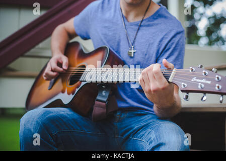 Ein junger Mann spielt eine Gitarre. Stockfoto