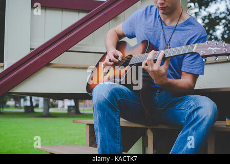 Ein junger Mann spielt eine Gitarre. Stockfoto