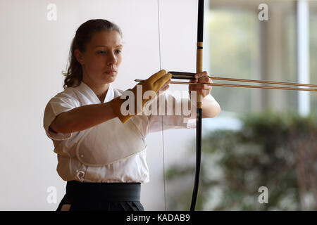 Kaukasische Frau Kyudo praktizieren Traditionelles japanisches Bogenschießen Stockfoto