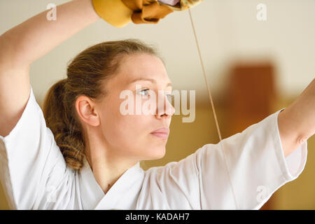 Kaukasische Frau Kyudo praktizieren Traditionelles japanisches Bogenschießen Stockfoto