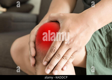 Das Knie Mann hält auf Leiden, Schmerzen im Knie Nahaufnahme. die Läsion in rot markiert ist. Stockfoto