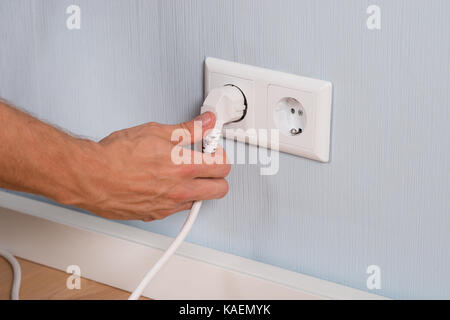 Nahaufnahme von Hand Einfügen eines elektrischen Stecker in eine Steckdose. Stockfoto