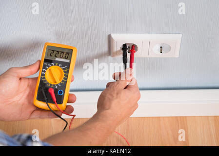 Nahaufnahme der Person dosiergerät Buchse Spannung mit einem digitalen Multimeter Stockfoto