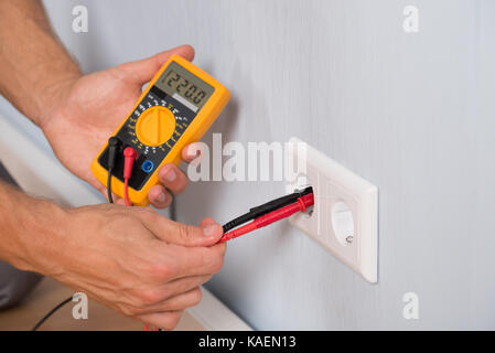 Nahaufnahme der Person dosiergerät Buchse Spannung mit einem digitalen Multimeter Stockfoto