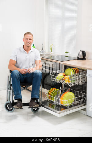 Junge Glücklich behinderte Menschen auf Rollstuhl In der Küche Stockfoto