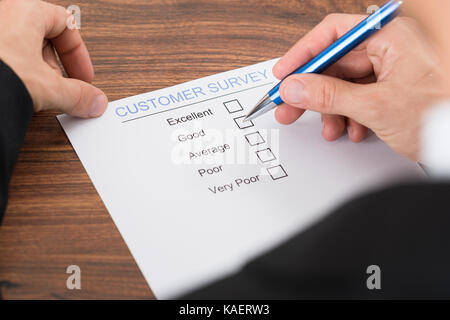 Nahaufnahme der Person Hand Befüllen Kundenfragebogen mit Stift Stockfoto