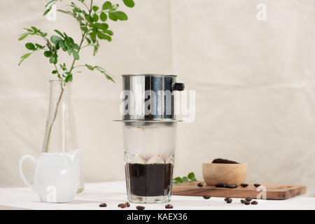 Kaffee tropft im vietnamesischen Stil auf hölzernen Tisch Stockfoto