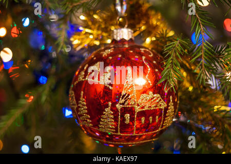 Weihnachten Hintergrund. close-up Weihnachten Spielzeug rot glas kugel, bemalt mit Gold, hängt an der Tanne. Stockfoto