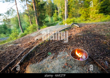 Teelicht Kerze auf Rock gegen Bäume Stockfoto