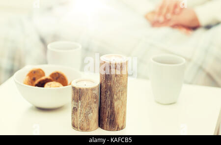 In der Nähe von Kerzen, Plätzchen und Kaffee Tassen auf dem Tisch Stockfoto