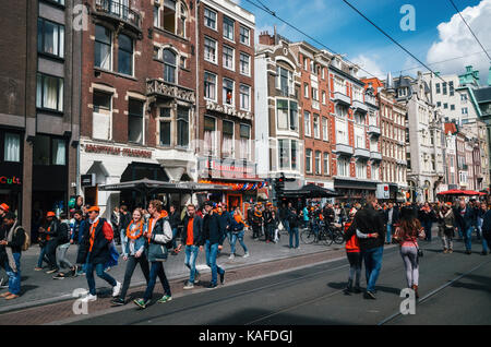 Amsterdam, Niederlande - 27 April 2017: Straßen von Amsterdam mit orange Dekorationen voller Menschen in Orange während der Feier der Könige. Stockfoto