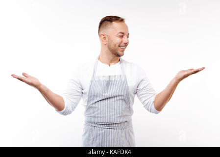 Optimistischer Mann auf weißem Hintergrund mit ausgebreiteten Händen posing Stockfoto