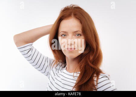 Charmante Frau mit der Hand auf der Rückseite des Kopfes posing Stockfoto