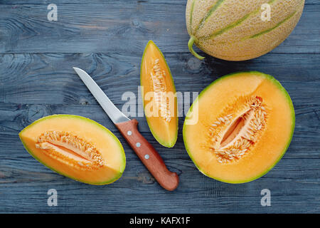 Frische Melone in kleine Stücke schneiden auf hölzernen Tisch. Stockfoto