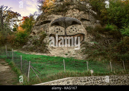 Bergige Überstand mit kleinen Höhle ist ähnlich wie auf dem Kopf Löwe am Rand der Spur Stockfoto