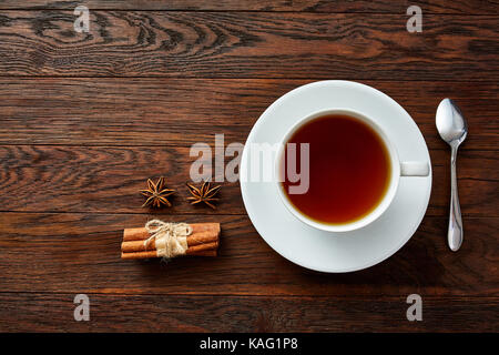 Weißes Porzellan Tasse Tee mit Zimtstangen, Zitrone, Minze und Teesieb Stockfoto