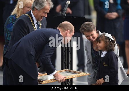 Der Herzog von Cambridge erhält ein Geschenk von lokalen Schüler Tegan, 8, bei einem Besuch der Milton Keynes stieg zum 50. Jahrestag von Milton Keynes zu markieren. Stockfoto