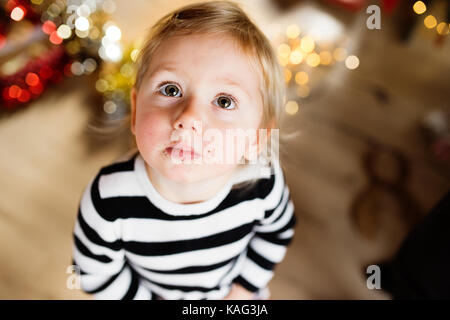 Süße kleine Mädchen in gestreiften Kleid, Krümel um ihren Mund. Stockfoto