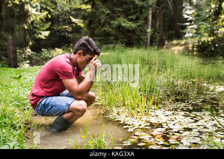 Teenager mit der Kamera in den See, wobei Bild. Stockfoto