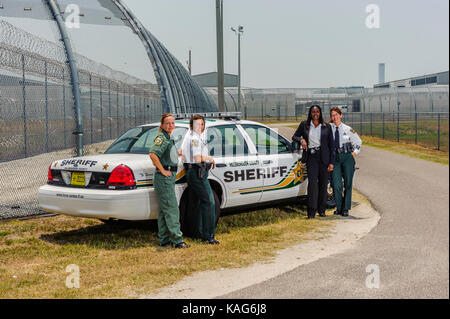 Vier weibliche Abgeordnete mit Office steht der Hillsborough County Sheriff's vor einem Streifenwagen am Gefängnis in Brandon, Florida USA. Stockfoto