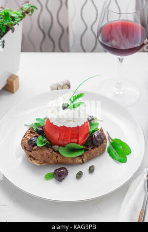 Dakos Gerste Zwieback mit mizitra Käse, Tomaten, Oliven, Oregano und Olivenöl. Kretischen Vorspeisen Stockfoto
