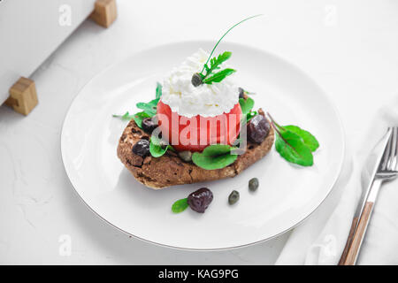 Dakos Gerste Zwieback mit mizitra Käse, Tomaten, Oliven, Oregano und Olivenöl. Kretischen Vorspeisen Stockfoto