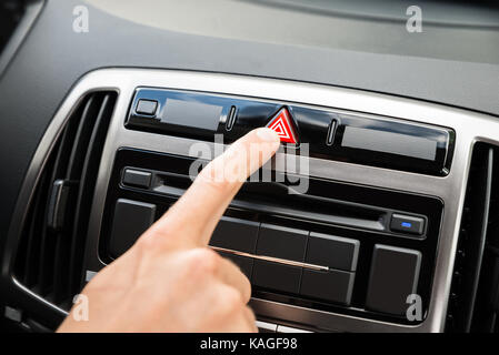 Nahaufnahme der Hand betätigen Not-Aus-Knopf im Auto. Stockfoto