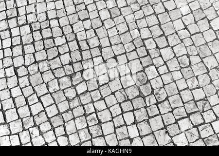 Typisch portugiesische Cobblestone handgefertigte Pflaster weißes Quadrat Fragmente. Lissabon, Portugal Stockfoto