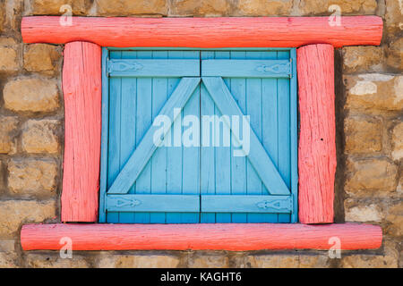 Mit blauen geschlossenen Fensterläden und roten Rahmen im alten Steinmauer, Hintergrund Foto Fenster Schärfung Stockfoto