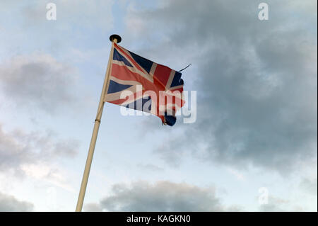 Tattered Union Jack unter stürmischen Himmel fliegen Stockfoto