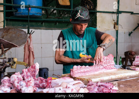 Havanna, Kuba eine Kubanische Metzger arbeitet an einem Stück Fleisch in einem Markt, in Centro Habana, Havanna, Kuba. Stockfoto