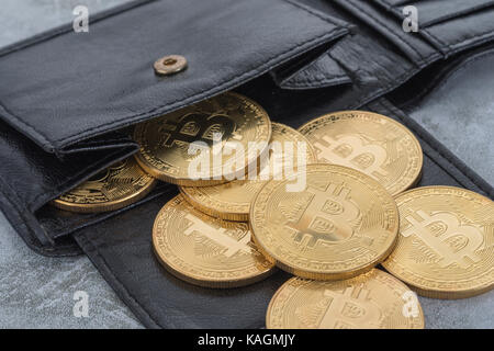 Gold Bitcoins verschüttet aus schwarzem Brieftasche. Für Bitcoin-Wallet, virtuelles Geld, Kryptowährung, Peer-to-Peer-Transaktionen, Bitcoin-Preisabsturz. Stockfoto