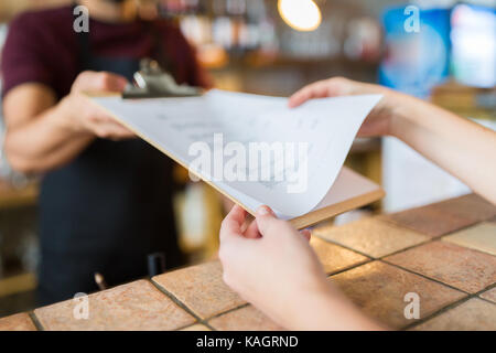 Barkeeper, Menü, um Kunden an der Bar Stockfoto