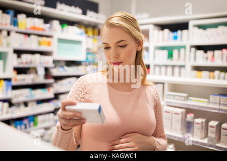 glücklich schwanger Frau mit Medikamenten in Apotheke Stockfoto