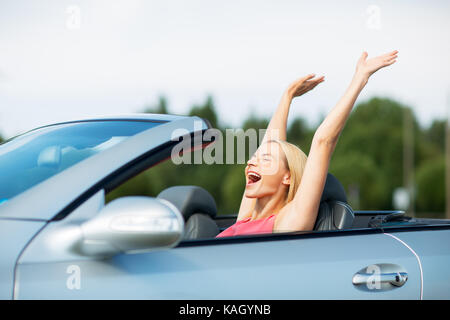 Glückliche junge Frau in Cabrio Stockfoto