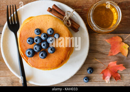 Kürbis Pfannkuchen mit Heidelbeeren und Honig auf Holztisch. Detailansicht, horizontal Stockfoto