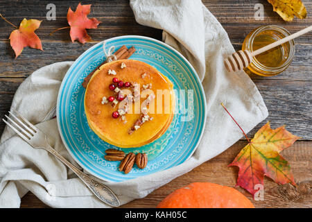 Kürbis Pfannkuchen mit Honig, Pecan Nüsse und Beeren auf einem Teller. Tabelle Ansicht von oben. Hausgemachte Kürbis Pfannkuchen Herbst essen Stockfoto