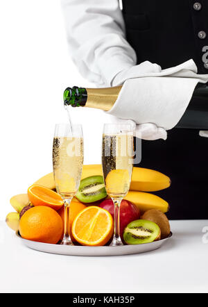 Kellner gießt in Glas Champagner auf weißem Hintergrund. Romantisches Abendessen Stockfoto