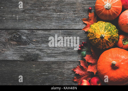 Herbst Herbst frame Komposition mit Kürbisse ernten und gefallenen Ahornblätter auf hölzernen Hintergrund. Ansicht von oben mit Platz für Text kopieren Stockfoto