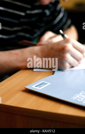 Ein Mann füllt ein Formular für die Polizei. Newport, South Wales. 20.03.2006. Stockfoto