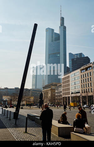 Frankfurt am Main, Deutschland - 16 März 2017: Schräge gelochtes Rohr auf Goethe Platz mit ruhenden Menschen gegen die Commerzbank Tower Stockfoto