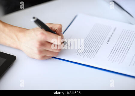 Junge Unternehmer Unterzeichnung Dokument am Tisch in Weiß Büro close-up Stockfoto