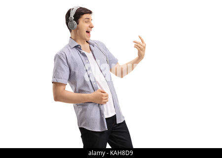 Junger Mann, der ein Paar Kopfhörer und spielen eine luftgitarre auf weißem Hintergrund